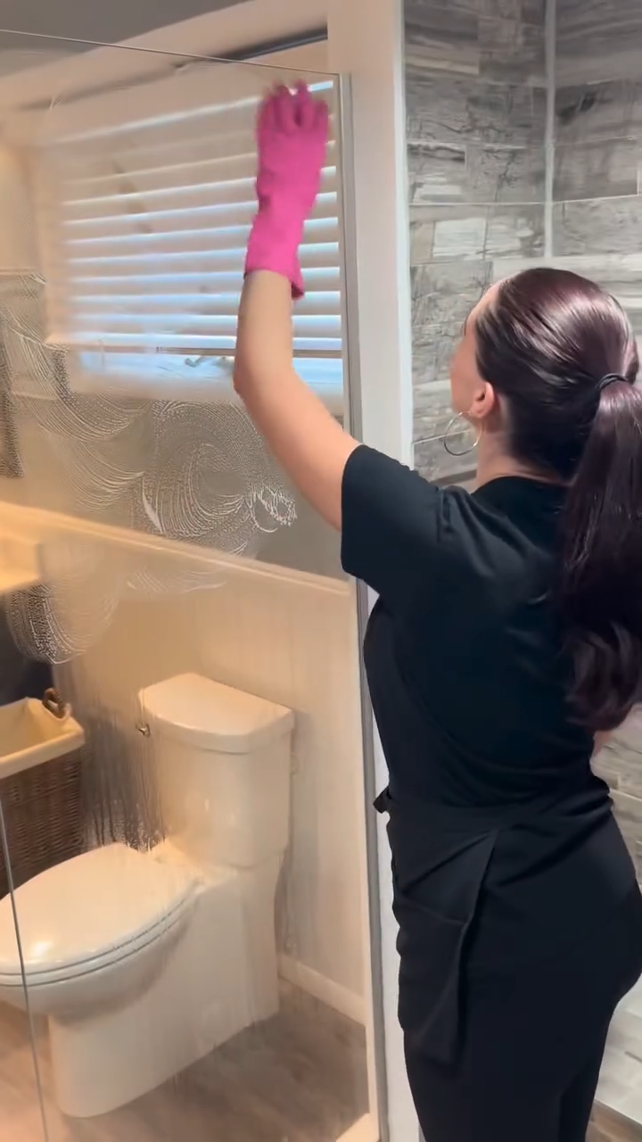 Cleaner finishing a glass shower